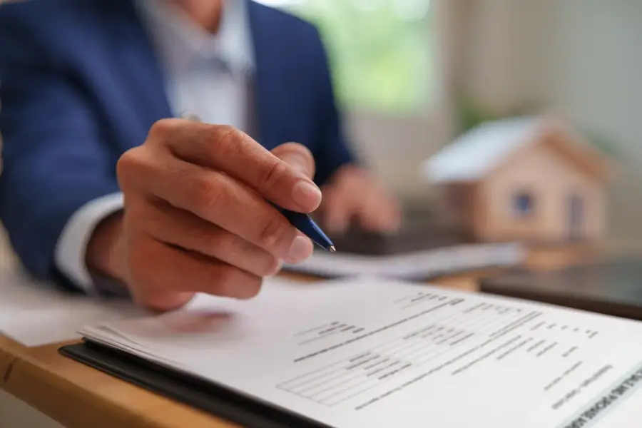Homeowner reviewing a printed plumbing estimate at a kitchen table